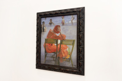 Girl in a red dress reading by a swimming pool