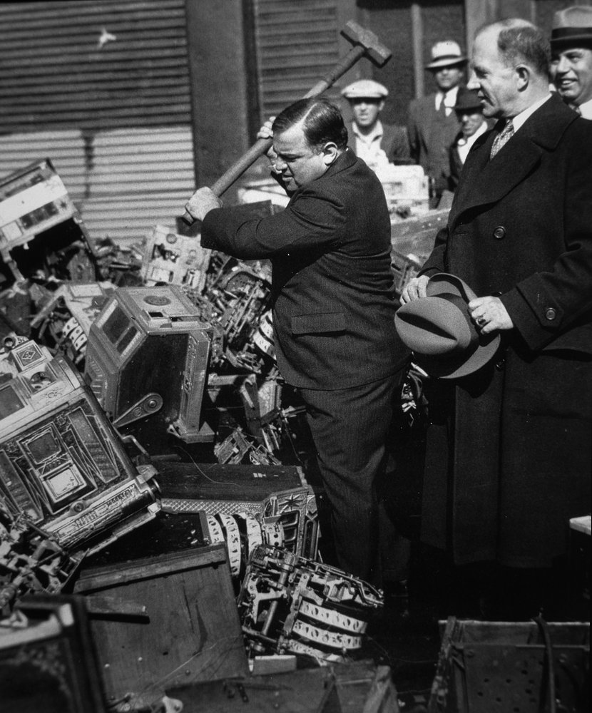 Fiorello La Guardia (1882-1947) smashing confiscated slot machines