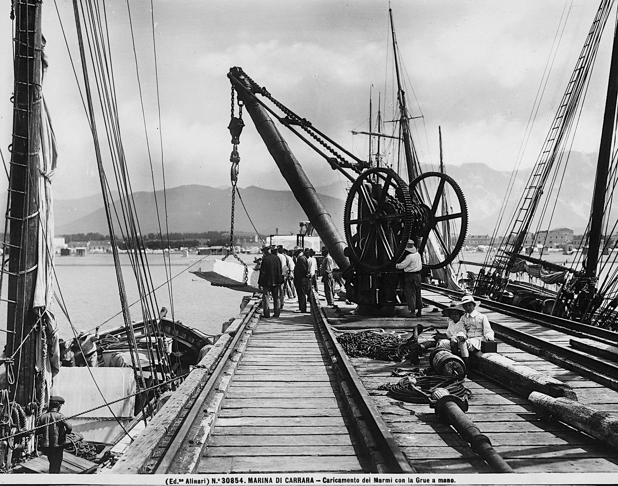 Loading blocks of marble with a hand crane in Marina di Carrara by Fratelli Alinari