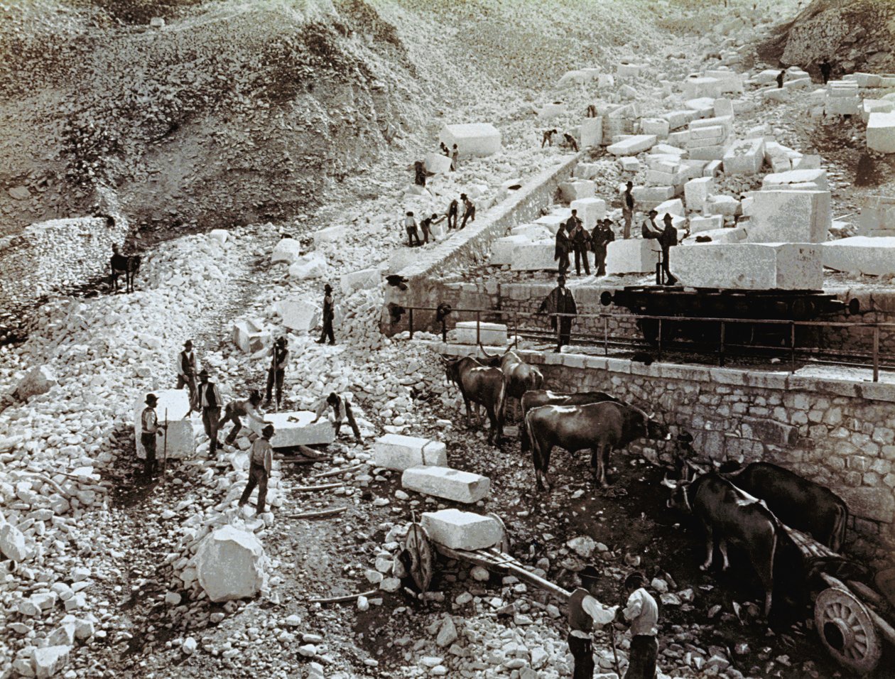 Railway station with laborers loading marble blocks onto railway wagons, three pairs of oxen with transport wagons are visible by Fratelli Alinari
