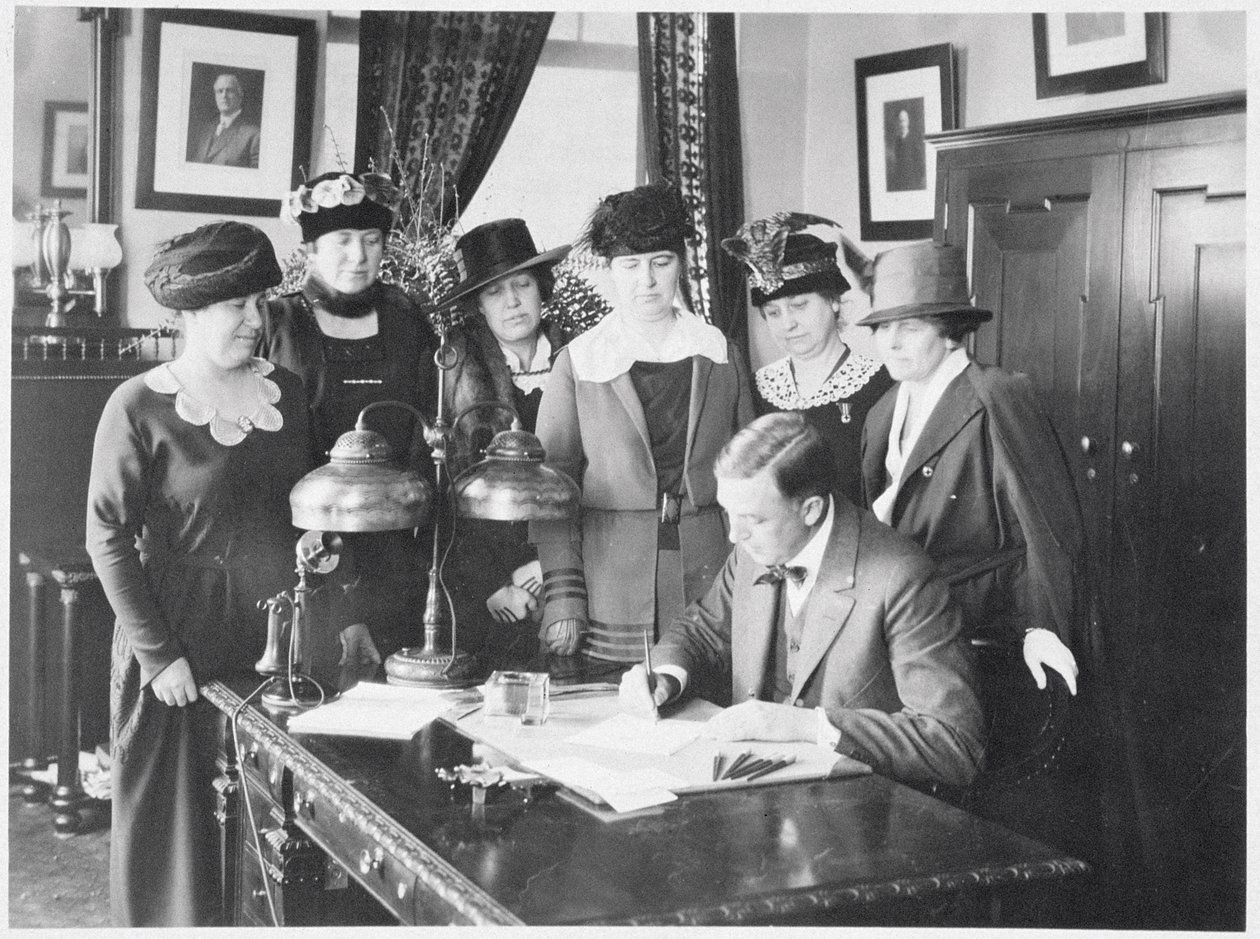 Governor Carl Elias Milliken Signing the Suffrage Bill as Six Women Look On by American Photographer