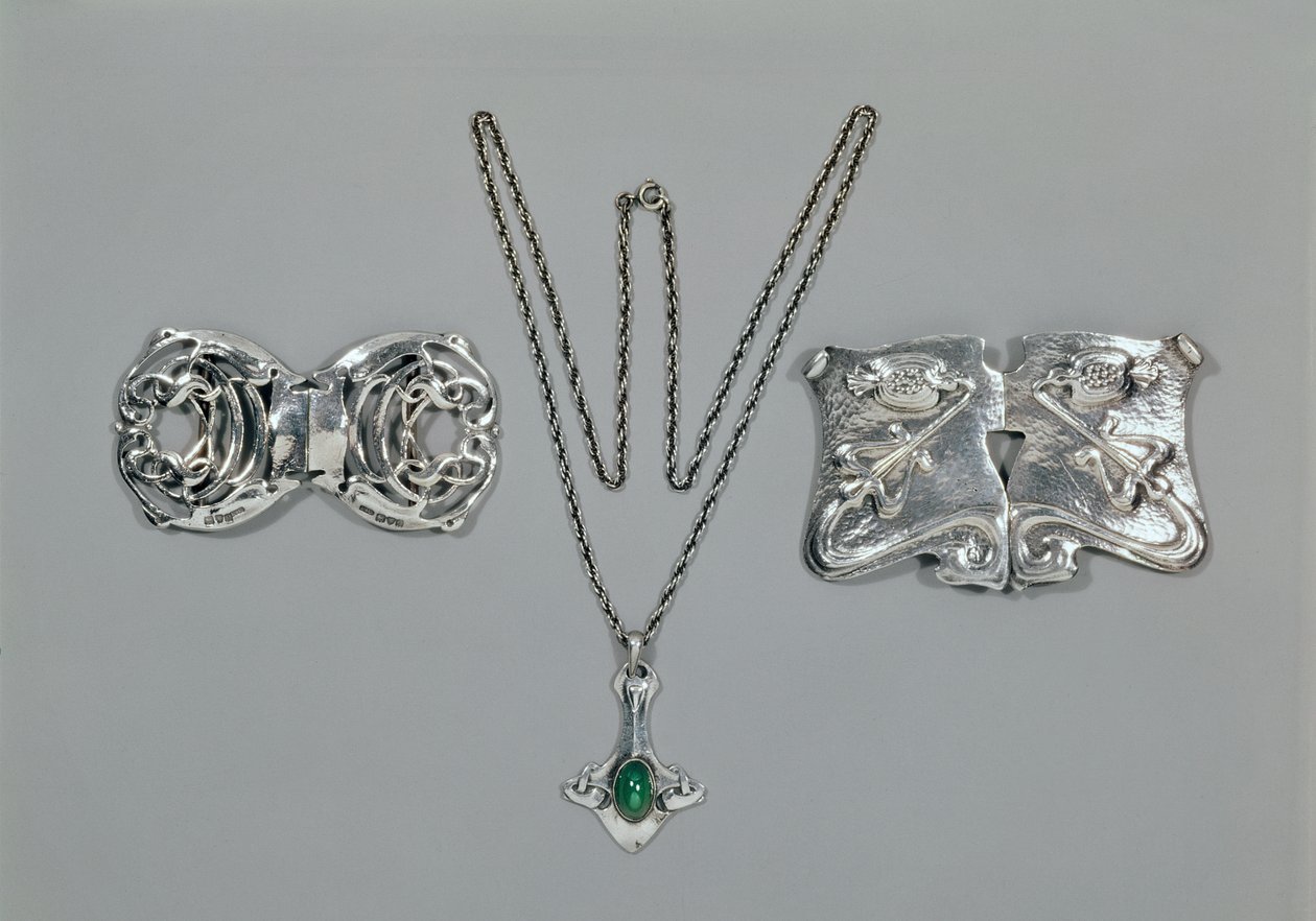 Silver jewellery designed for Liberty. Left to right: Waist clasp with interlaced Celtic design, 1904. Pendant and chain set with cabochon-cut chrysoprase. Waist clasp with repousse design on hammered by Archibald Knox