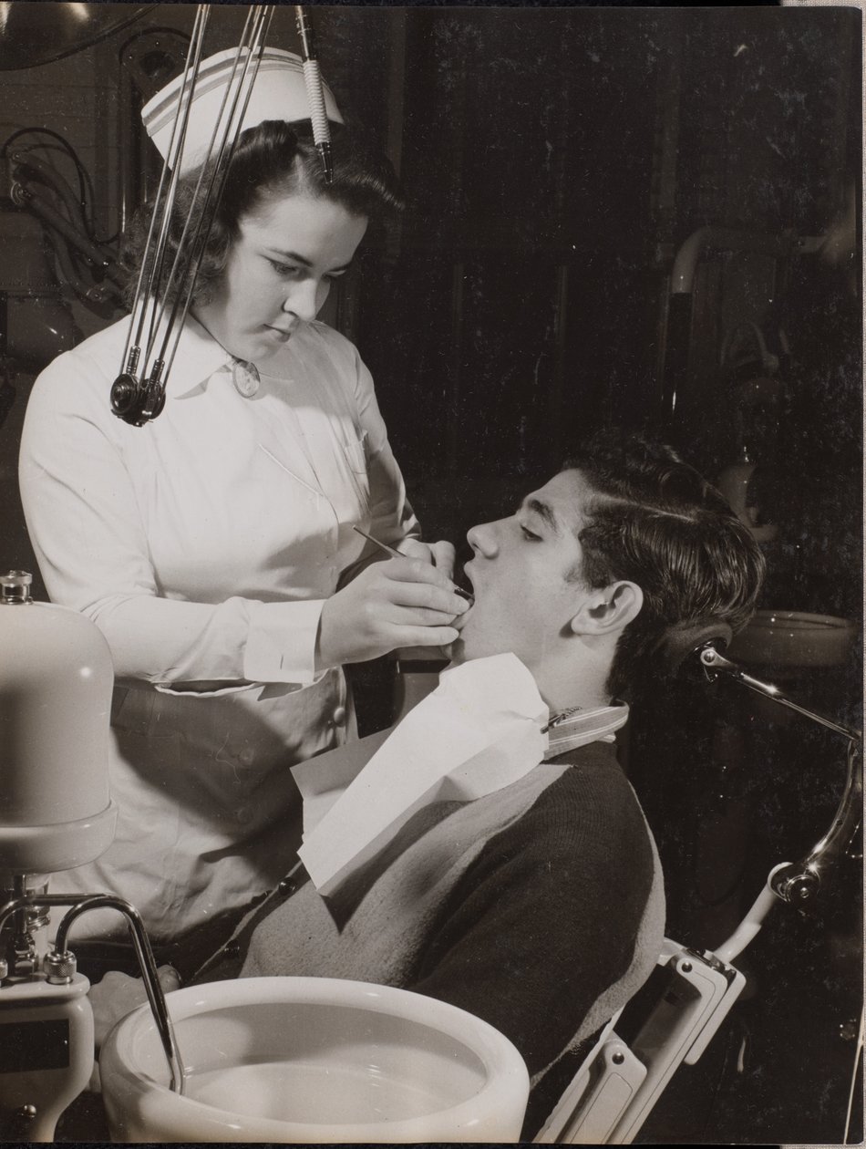Dental Hygienist Inspects a Patient