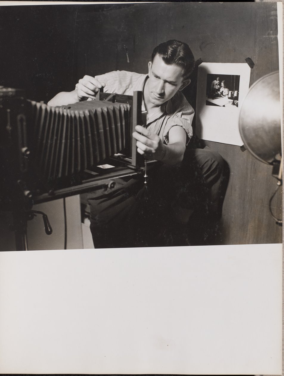 Man Adjusts Folding Bellows on a Large-Format Camera by Arnold Eagle
