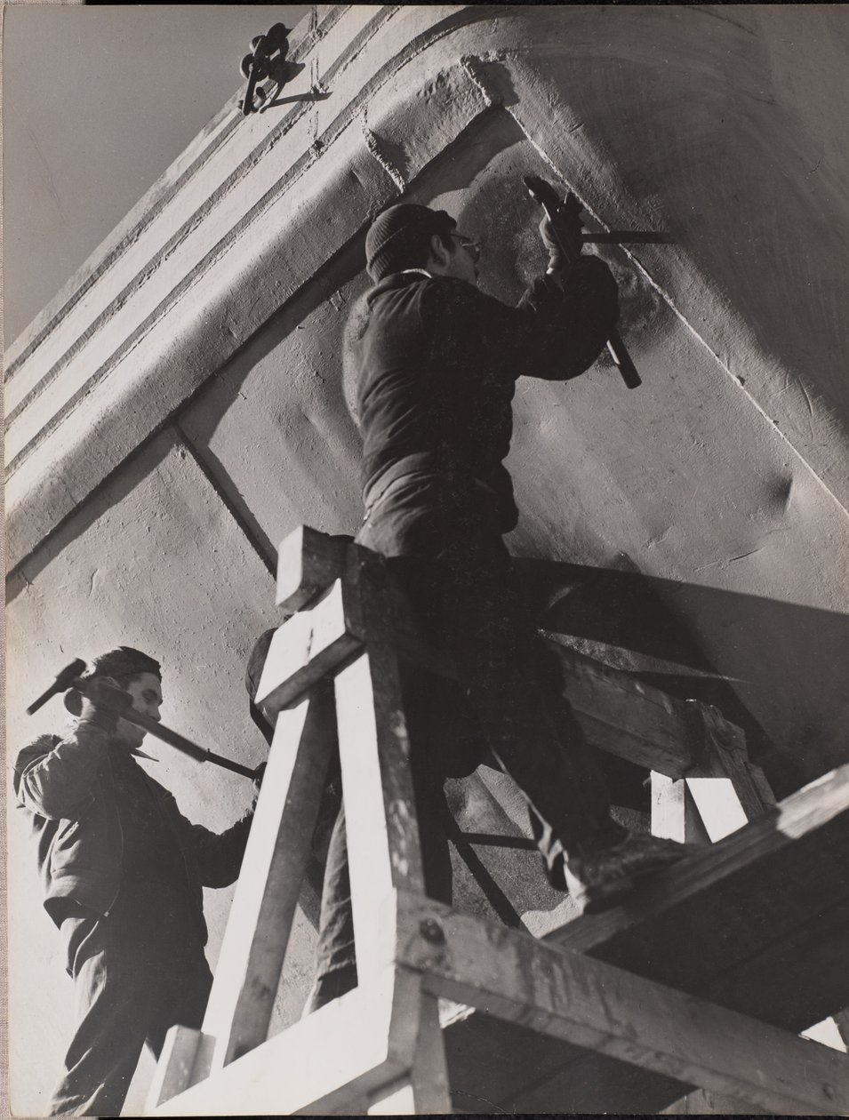 Two Men Work on the Underside of a Boat by Arnold Eagle
