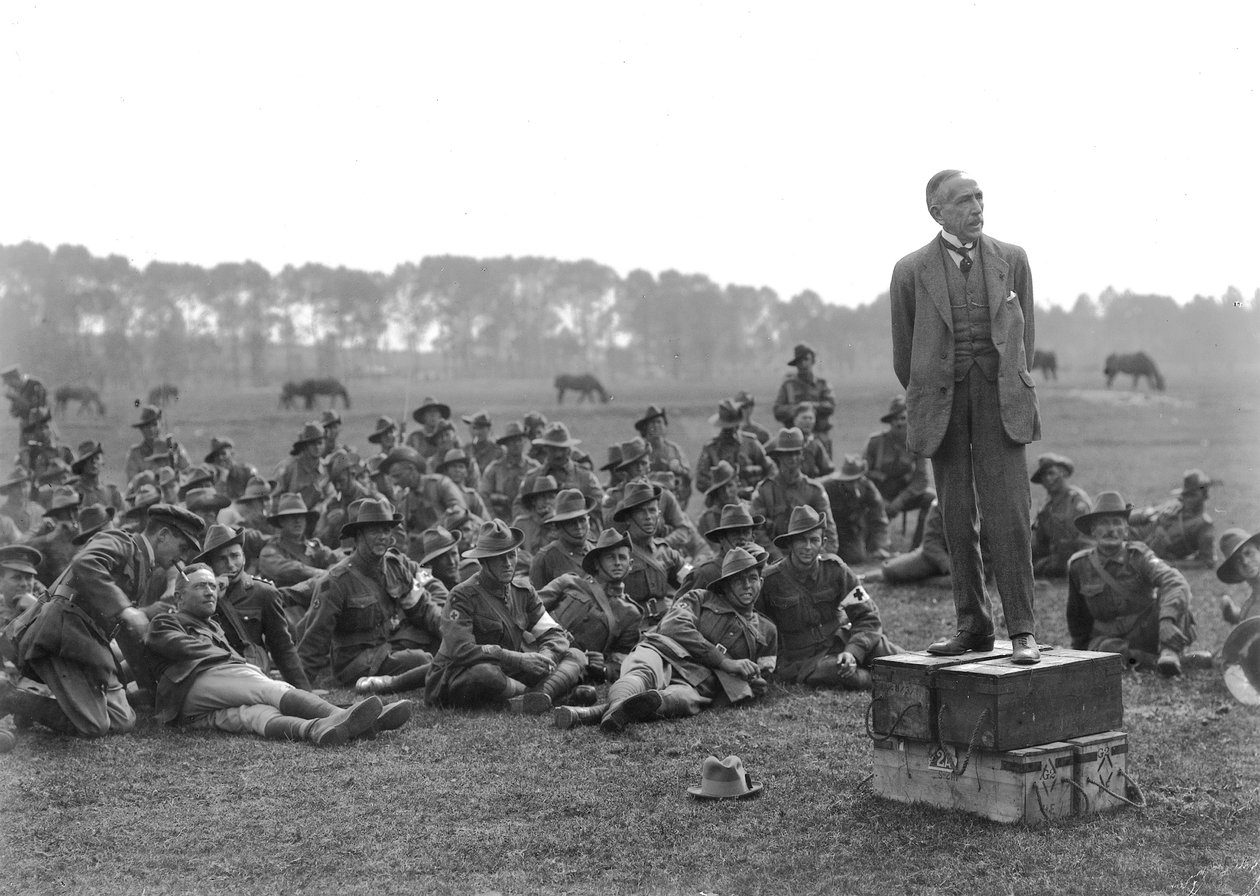 The Right Honourable William Morris (Billy) Hughes, standing on a platform composed of four ammunition boxes, addressing a gathering of the 5th Australian Field Ambulance, near La Motte by Australian Photographer