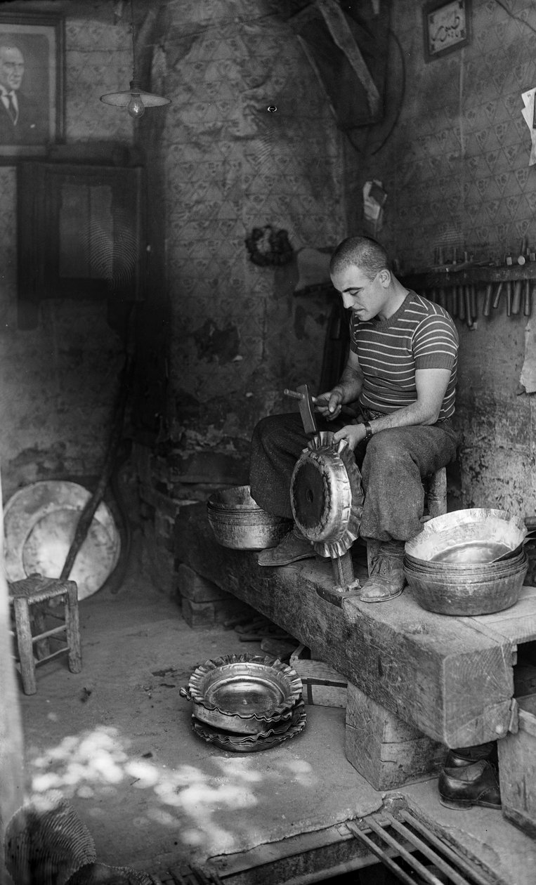 Italian metalworker hammering on a form sheet metal to make a raised vessel or pot, Italy by Bernard F. Rogers