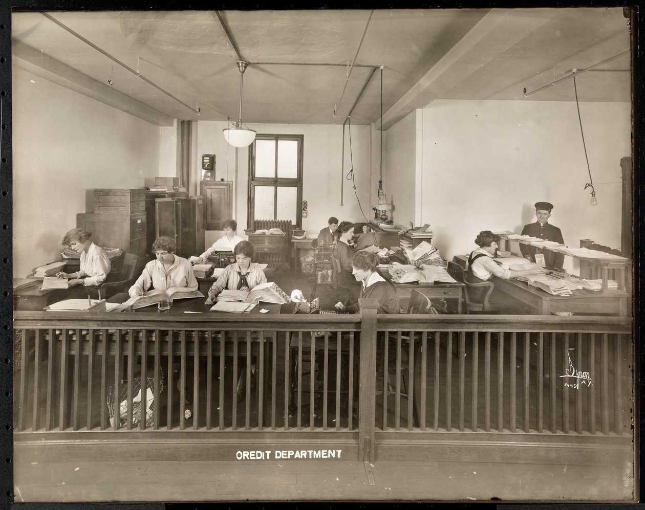 A Man and Woman Working in the Credit Office of the Mantle Lamp Co. of America, New York, 1915-16 by Byron Company