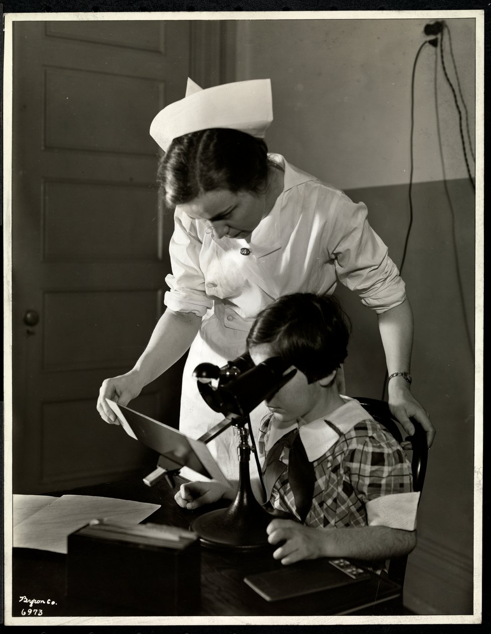 Nurse and a visually impaired girl at the clinic of the New York Association for the Blind, 114 East 60th Street, New York, 1934 by Byron Company