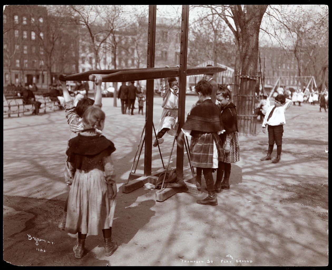 View of children playing on playground equipment at Tompkins Square Park, on Arbor Day, New York by Byron Company