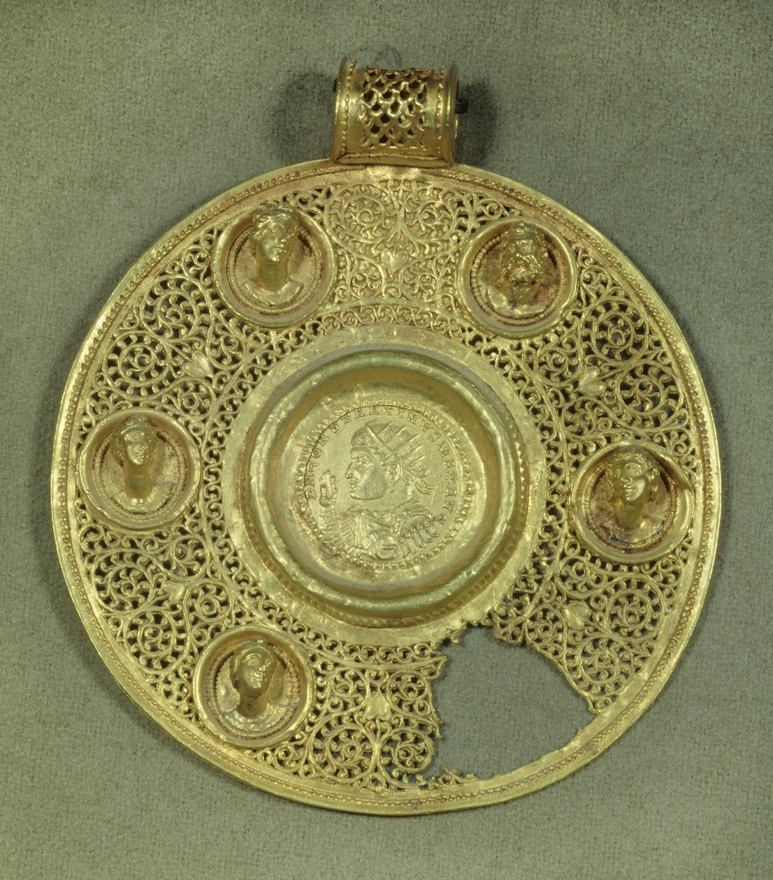 Gold circular medallion: solidus of Constantine I the Great (270-337 AD) struck at Sirmium in 321 AD, in an opus interrasile frame, adorned with 5 relief busts. 4th century AD. Paris, Musee du Louvre by Byzantine