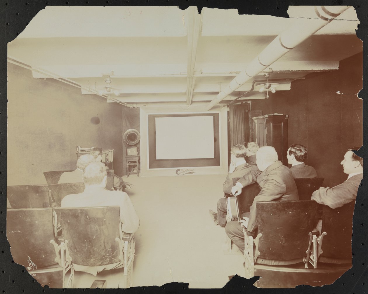 Cinephone Co. a theater at 124 E. 25th Street, with men seated in front of the movie screen by Company Byron