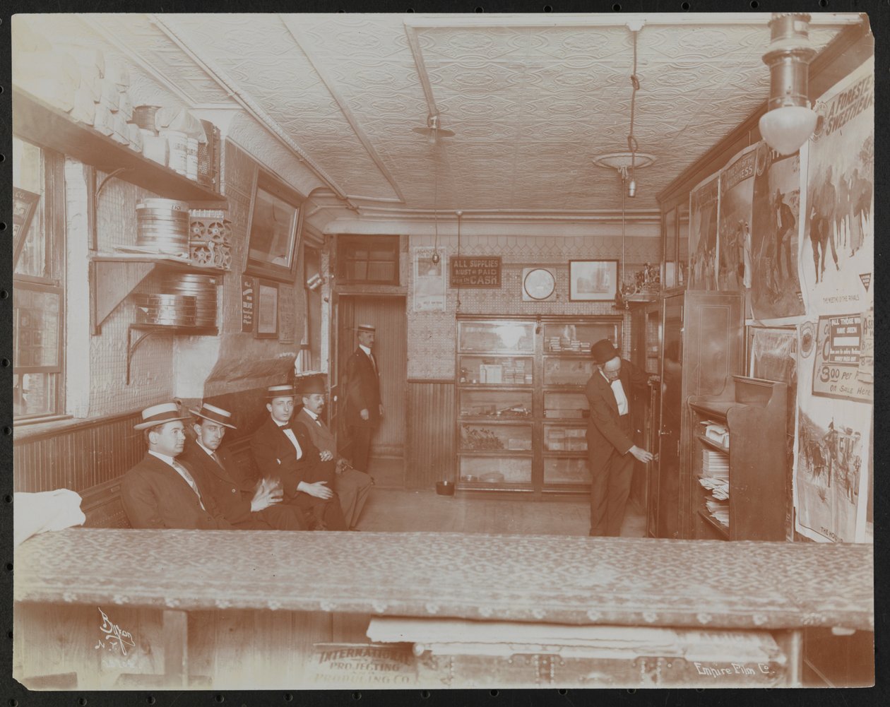 Empire Film Co (Possibly at Broadway and 55th Street) with Movie Posters on Wall and Customers Waiting by Company Byron