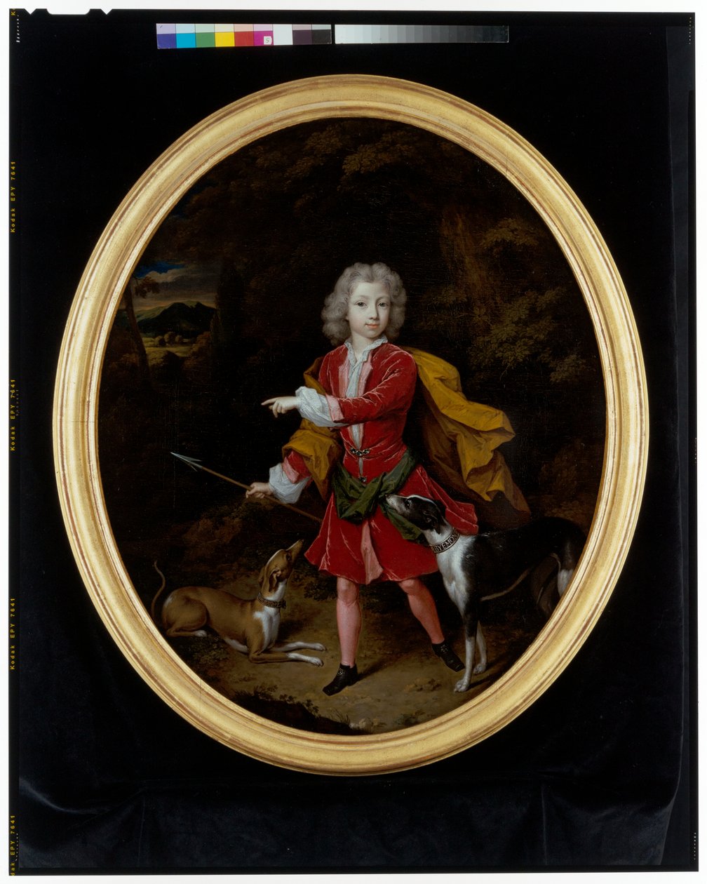 A portrait of a young man attended by a pair of hunting dogs in a wooded landscape by Constantin Netscher