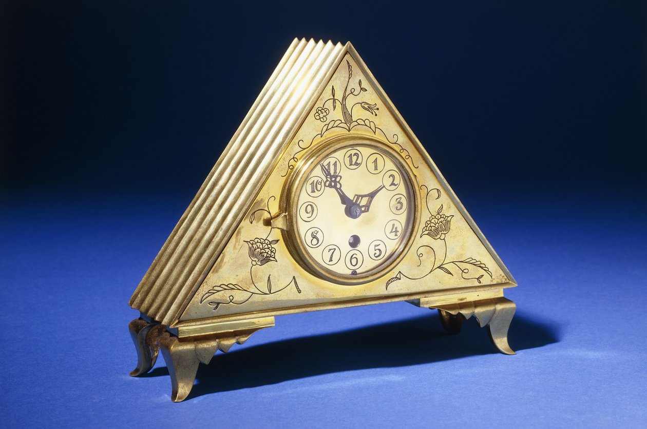 A Triangular Brass Table Clock with Engraved Floral Decoration by Dagobert (attr. to) Peche