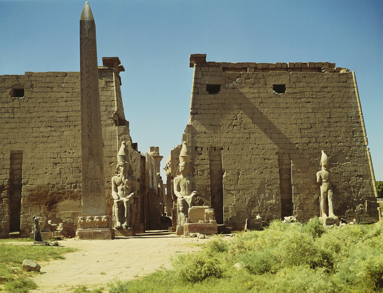 Facade and First Pylon with two seated statues of Ramesses II and the remaining obelisk by Egyptian 19th Dynasty