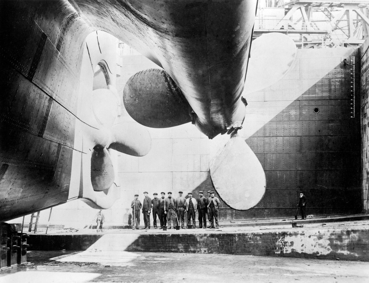 Workmen Standing under One of the Propellers of the Titanic, 31 May, 1911 by English Photographer