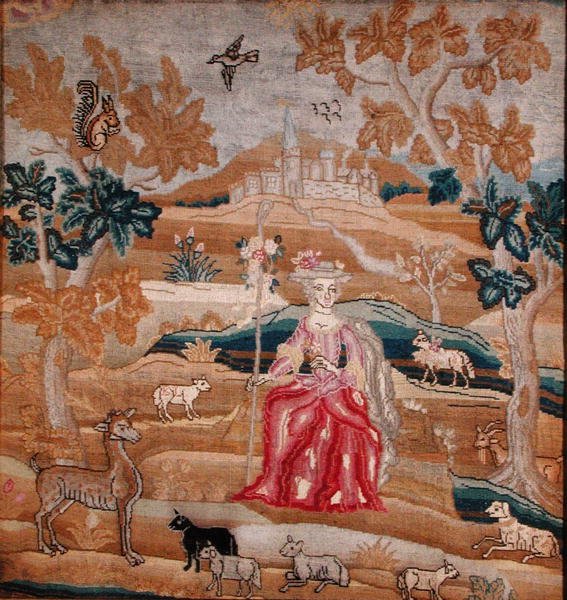 Embroidered panel depicting a shepherdess in front of a village by English School
