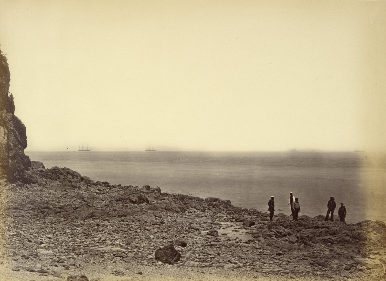 View of shore with ships on horizon and five figures standing on beach by Felice Beato