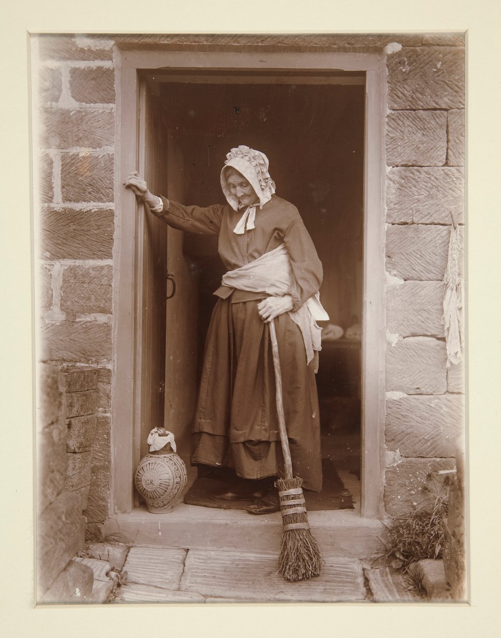 An Old Lady with a Yeast Bottle at a Cottage Door by Frank Meadow Sutcliffe