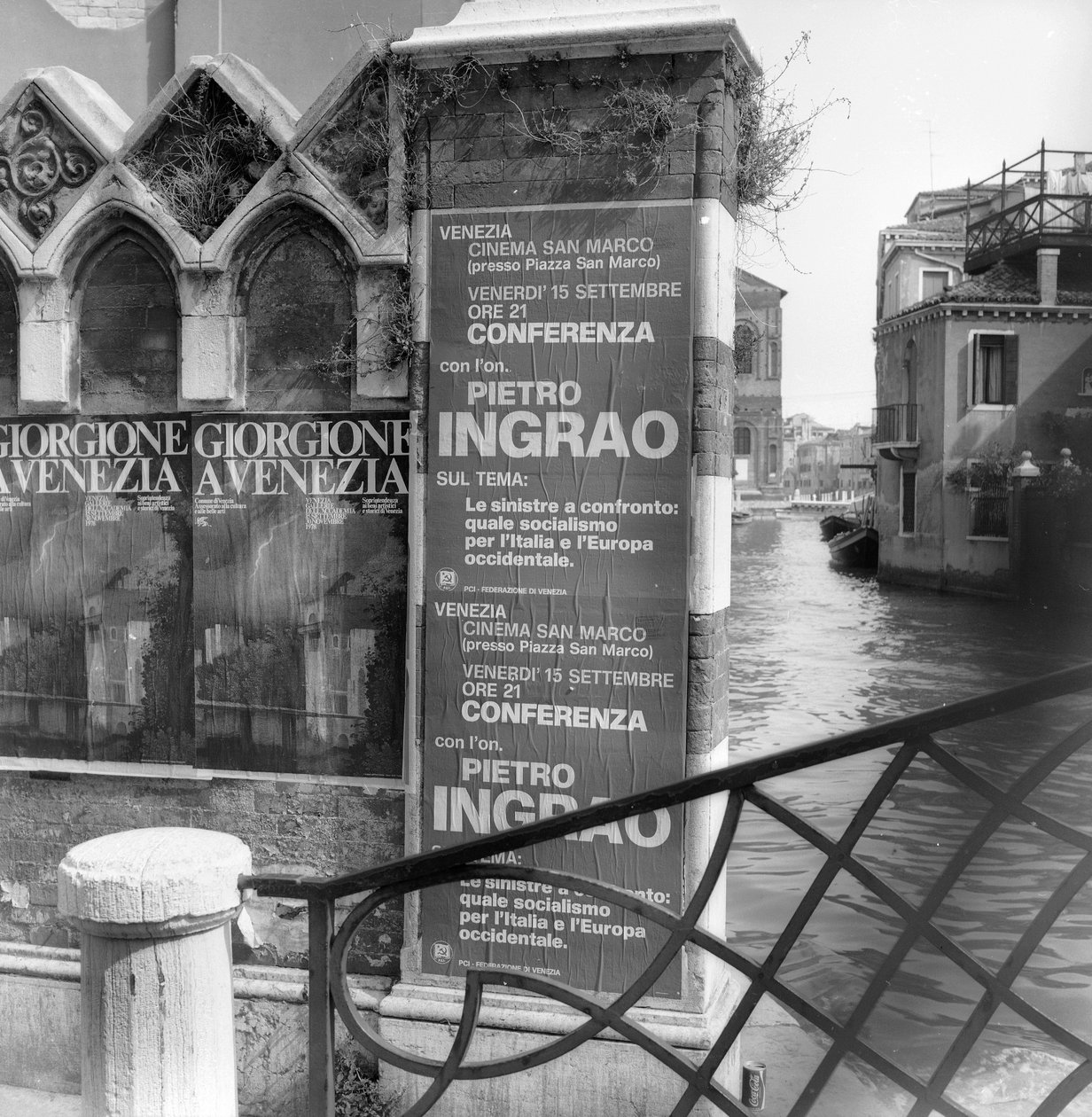 View of a canal in Venice with posters advertising a Giorgione exhibition and a political manifesto in foreground by Italian Photographer