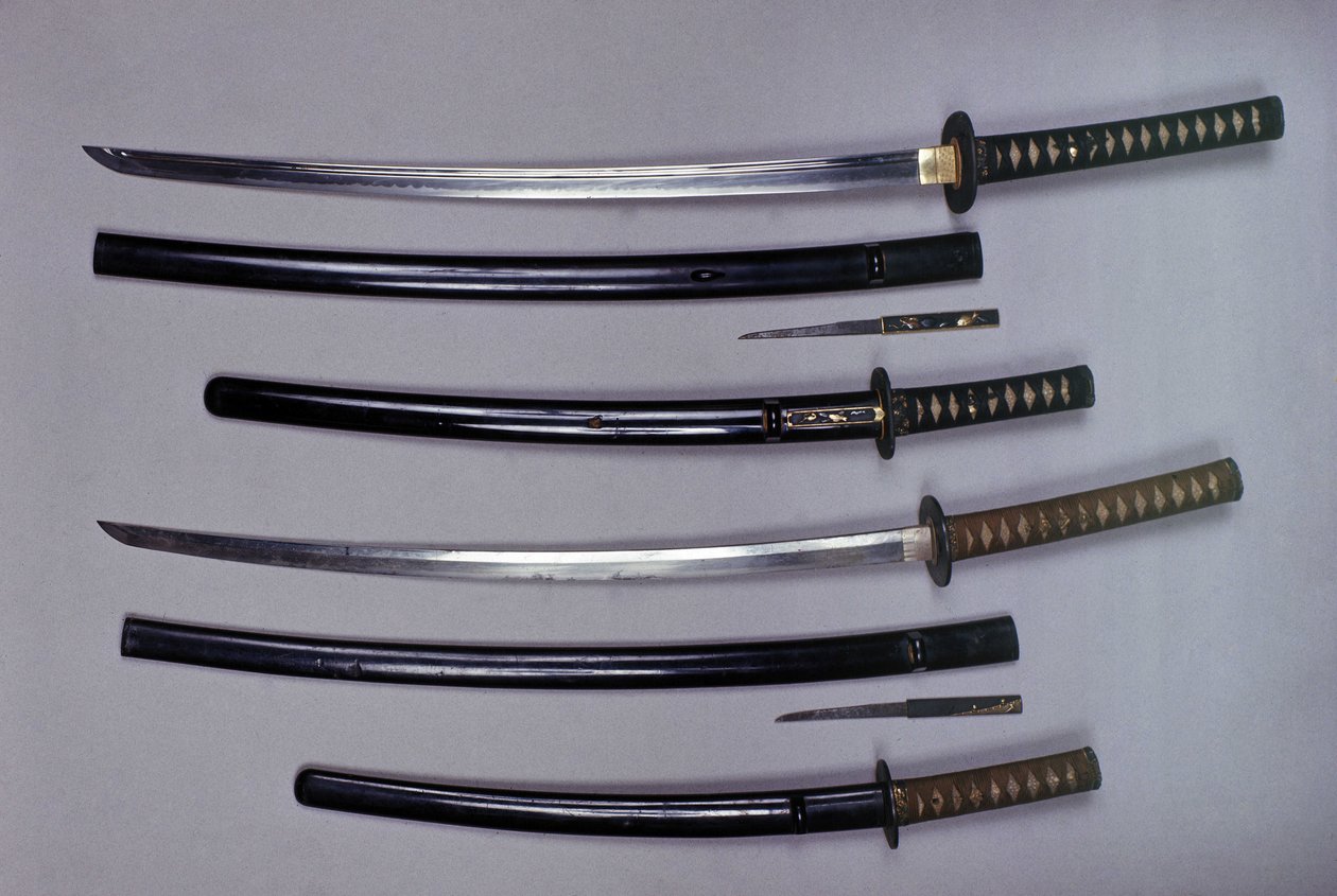 Top: a katana, Japanese sword and its sheath, wakizashi, Japanese short sword in its sheath, small Kokatawa dagger stows in the same scabbard. All three are from the 18th century. The lower ones are from the 17th century by Japanese School