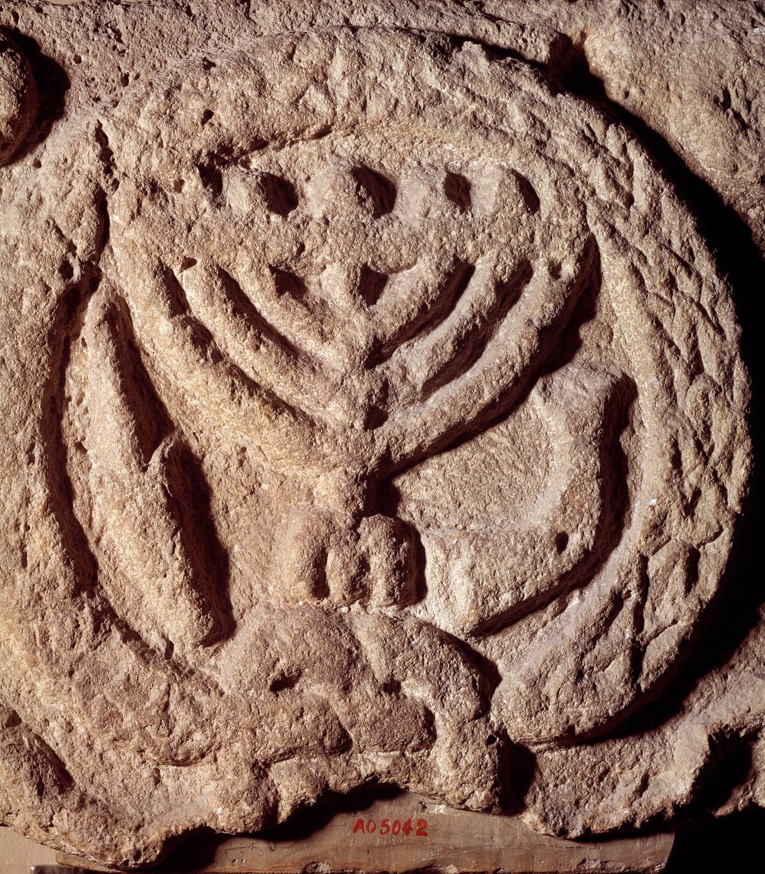 Judaism: architectural element in basalt of a synagogue decorated with a candlestick with seven branches (Menorah), palm and trumpet. From Transjordan. About 100 AD. Paris, Louvre Museum by Jewish School