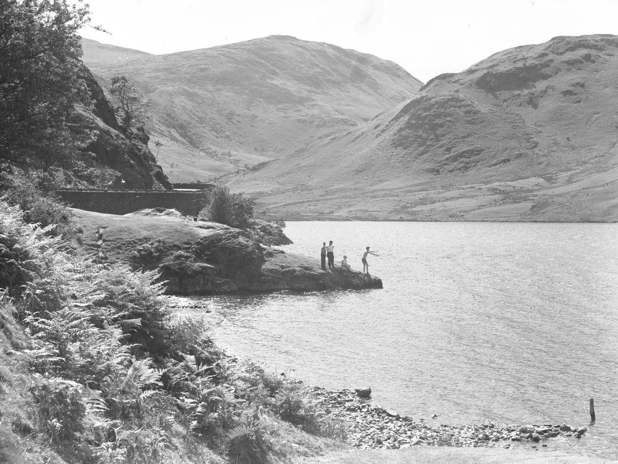 Three men and a woman on a rocky outcrop in the lake fishing, fells in background by Joseph Hardman