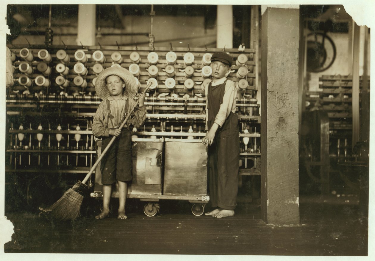 12 Year Old Doffer Ronald Webb and 7 Year Old Frank Robinson, Son of Cardroom Boss, Who Sweeps and Doffs at Roanoke Cotton Mills, Virginia, 1911 by Lewis Wickes Hine