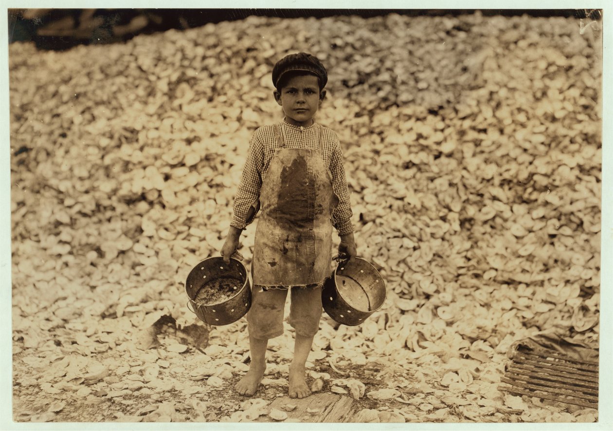 5 Year Old Migrant Shrimp-Picker Manuel in Front of a Pile of Oyster Shells, Working for a Second Year at Dunbar, Lopez, Dukate Company, Biloxi, Mississippi, 1911 by Lewis Wickes Hine