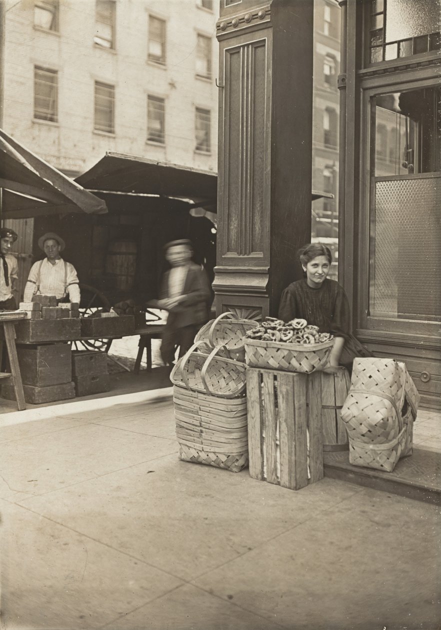 Lena Lochiavo - 11 years old, basket (and pretzel) seller, at Sixth Street Market in front of saloon entrance, Cincinnati, Ohio by Lewis Wickes Hine