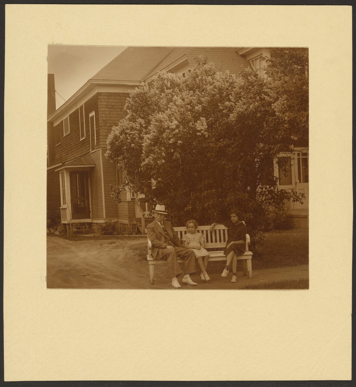Man and Young Girls on Bench Before House by Louis Fleckenstein