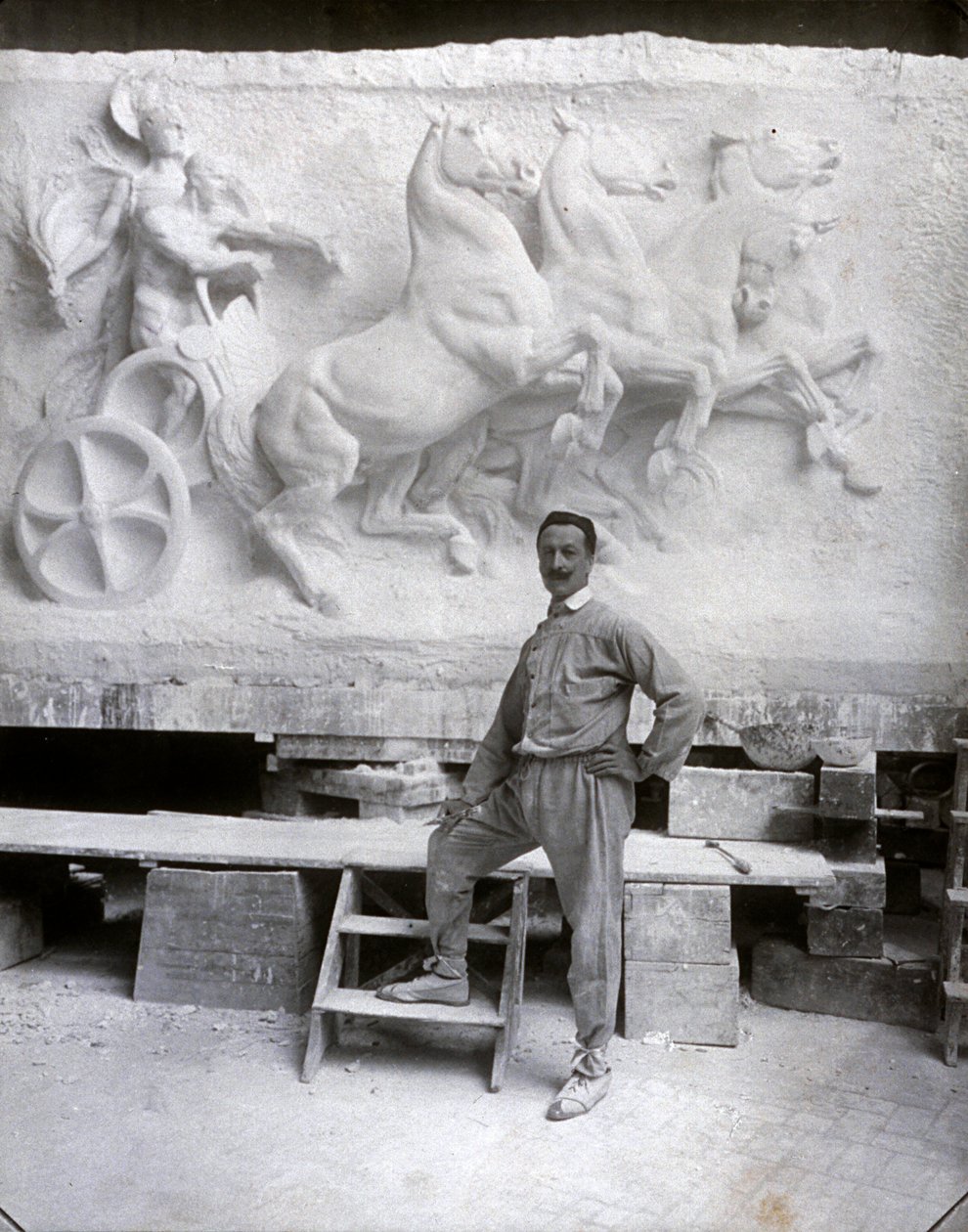 Full-Length Portrait of the Famous Sculptor Pietro Canonica. He is Posing in His Studio Before a Marble High Relief He is Working On (b/w photo) by Mario Nunes Vais