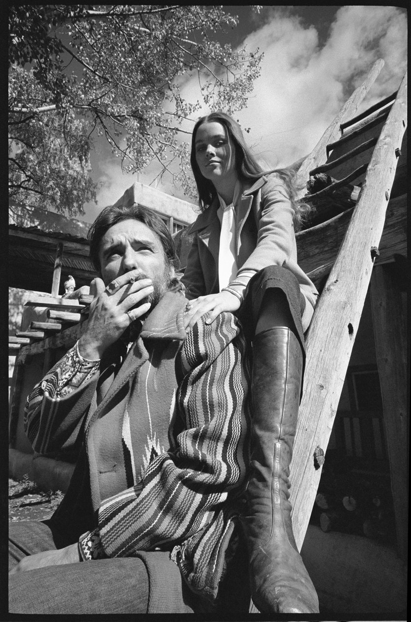 Dennis Hopper and wife Michelle Phillips on a ladder in New Mexico by Orlando Suero