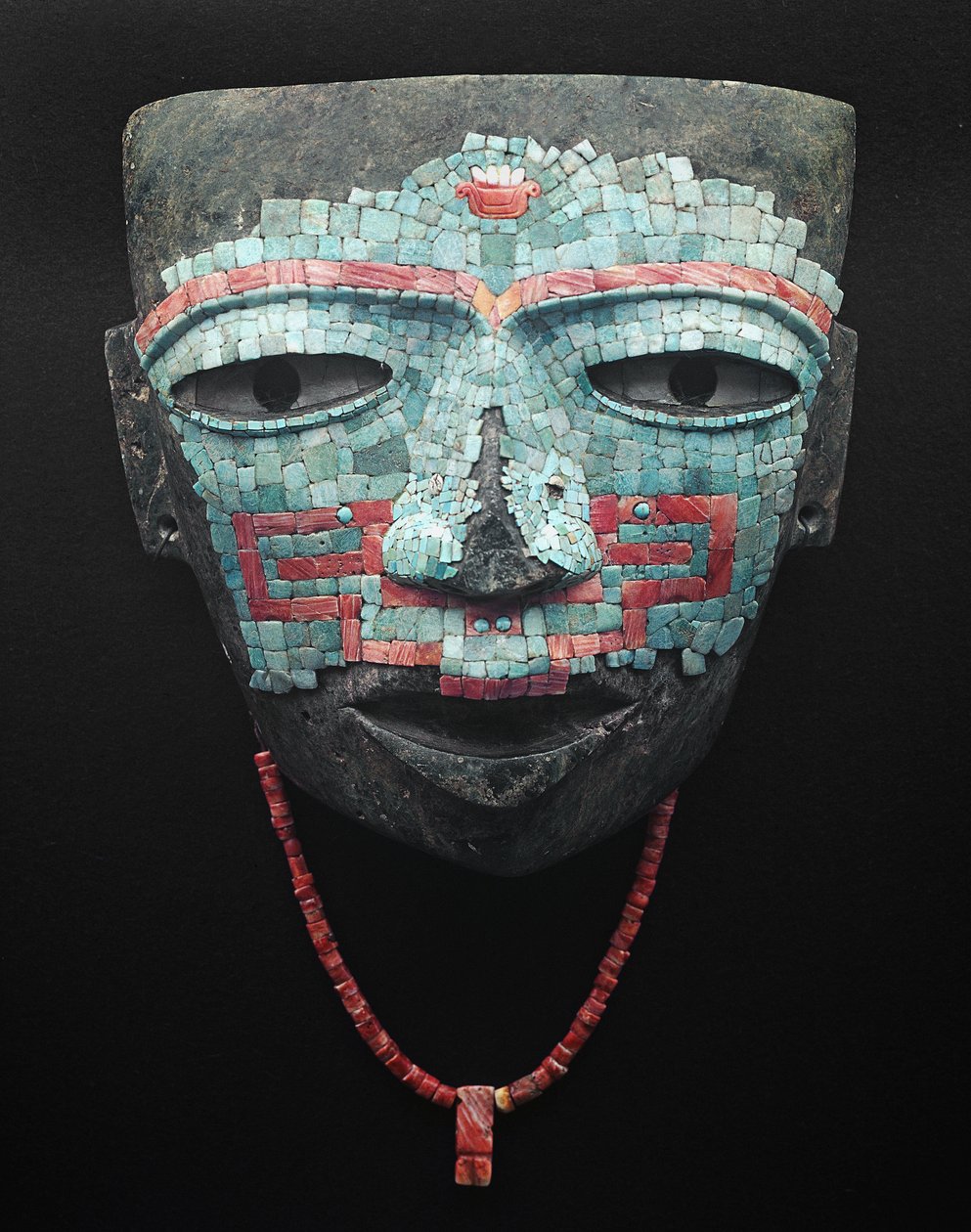 Funeral mask covered by turquoise and red shell mosaic. Artifact from Teotihuacan, Mexico City. Teotihuacan Civilization - Precolombian art: funeral mask of turquoise and pink stones dating from the civilization of Teotihuacan III (300-650 AD) by Pre Columbian Pre Columbian