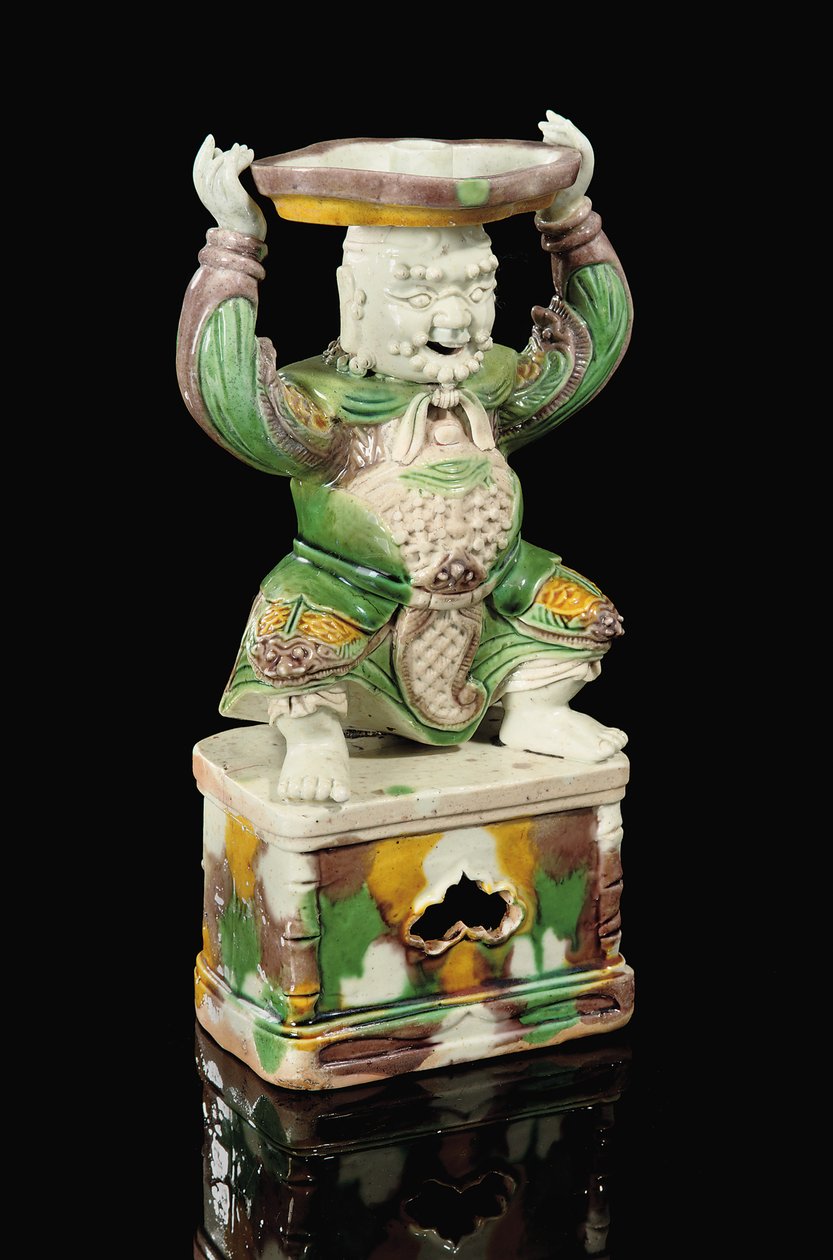 Egg and Spinach Glazed Pricket-Stick, Modelled as a Smiling Immortal with Scrolling Beard, Arms Raised to Support the Quatrefoil Pricket Attachment Balanced on His Head, Kangxi by School Chinese