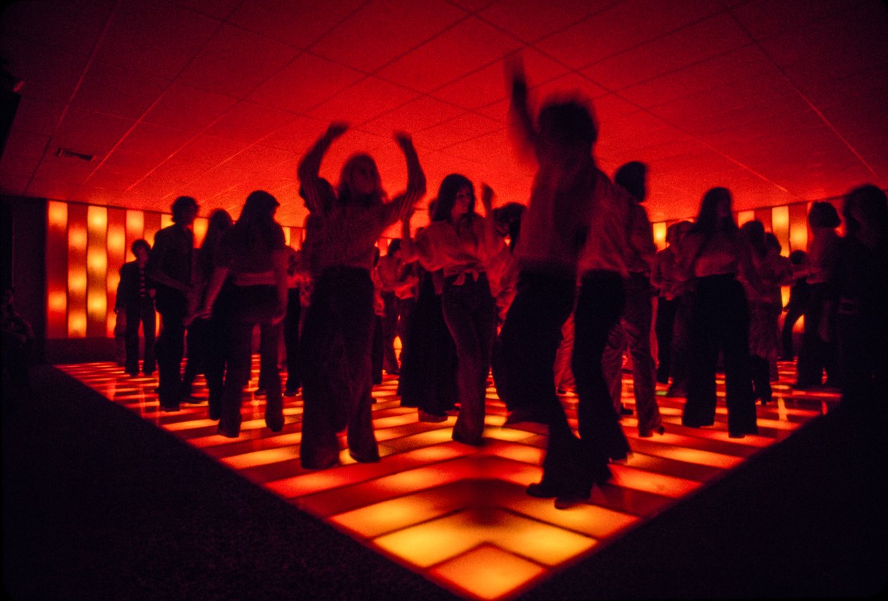 Young dancers at a nightclub dancing on an illuminated floor by Ted Spiegel