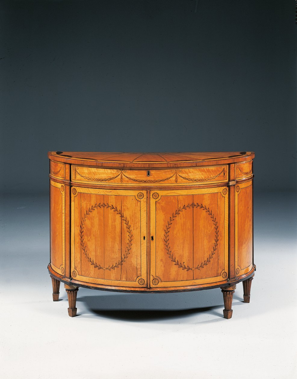 George III marquetry demi-lune commode, c.1760-79 by Thomas (attr.to) Chippendale