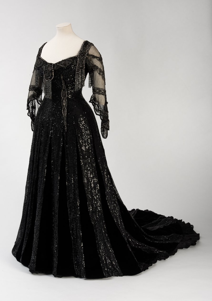 Black full length evening gown worn by Queen Alexandra, with bead and sequin decoration and incorporating Queen Alexandra’s signature black silk and gold lettered name tape, made by Barolet of Knightsbridge, London 1908-1910 by Unbekannt