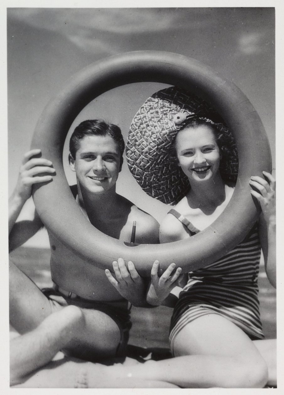 Man and woman looking through a rubber ring on beach, c 1935 by Unbekannt