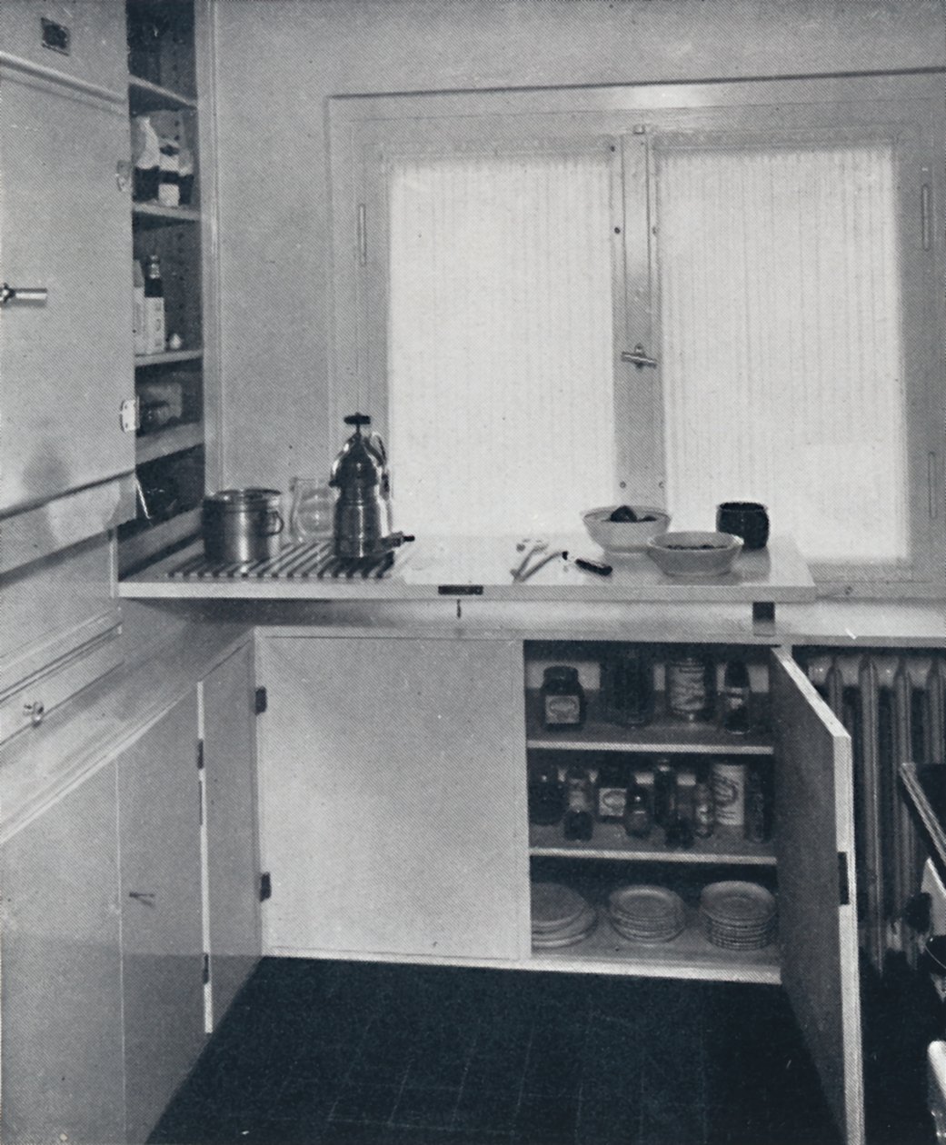 Kitchen with a black Dutch tiled floor, white walls and built-in shelves and cupboards by Unbekannt