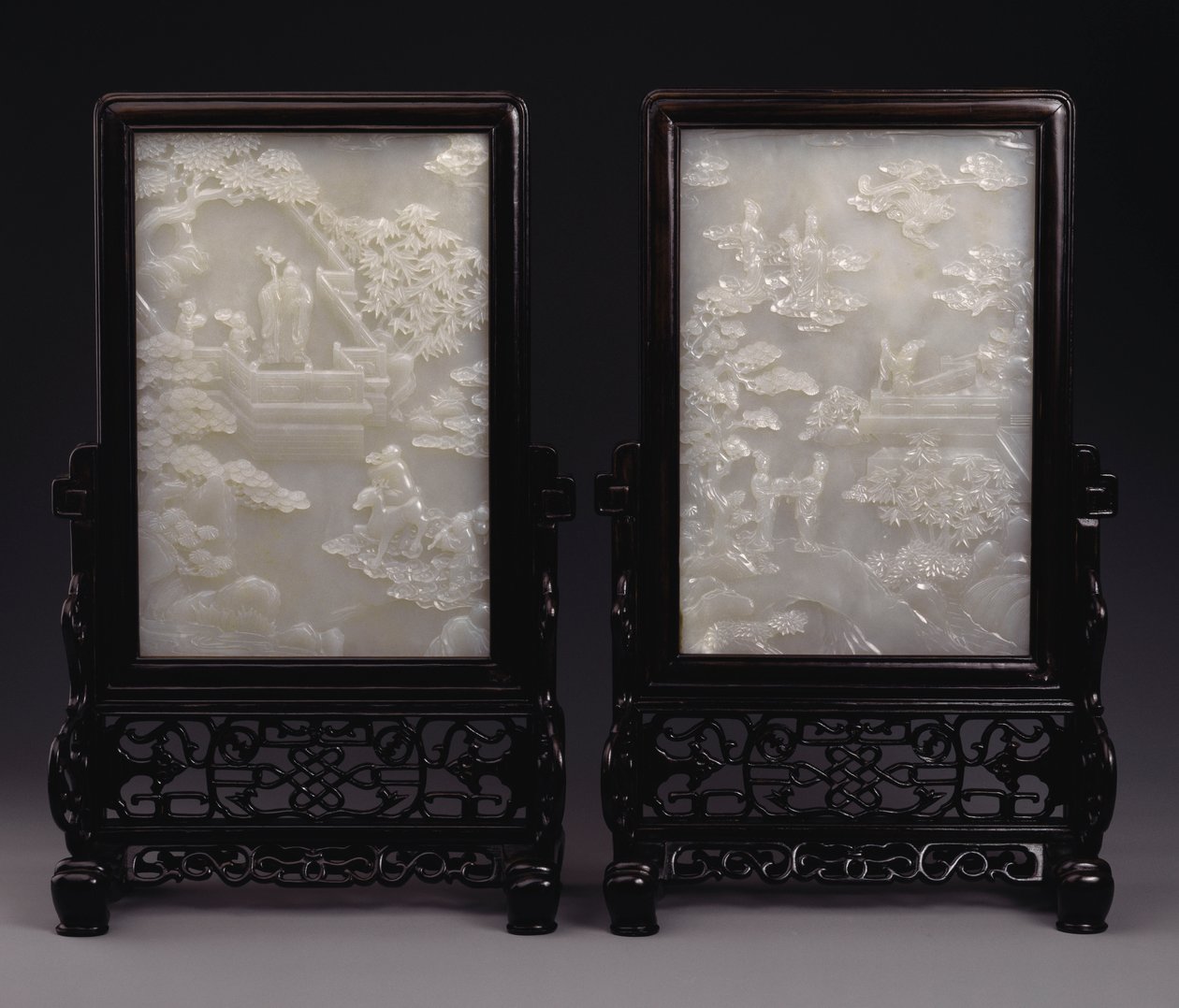 A pair of white jade table screens carved in relief with immortals amid clouds or in gardens with attendants and mythical beasts by Unbekannt