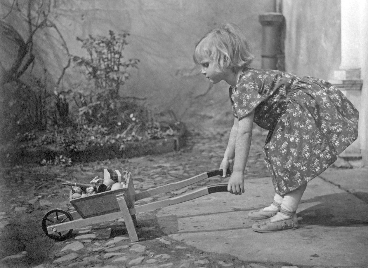 Little Girl Playing with a Wheelbarrow - 1931 by Unbekannt