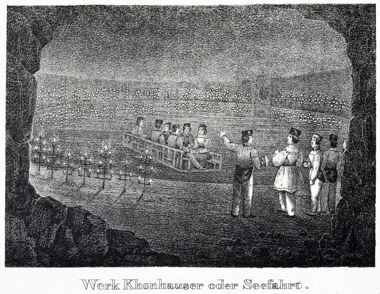 Salt mine: a group of visitors crossing the underground salt lake of the mine on a boat, in Durrnburg, Austria by Unbekannt