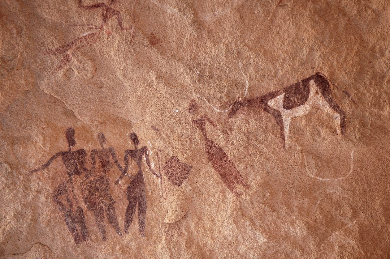Rock Art, Prehistory: Rock Painting of a Group of Characters and a Two-Tone Cow with Large Horns in an Ornate Shelter, in the Uweinat Massif, Egypt. (Period from 8000 to 3000 years BC). Photography by Unbekannt