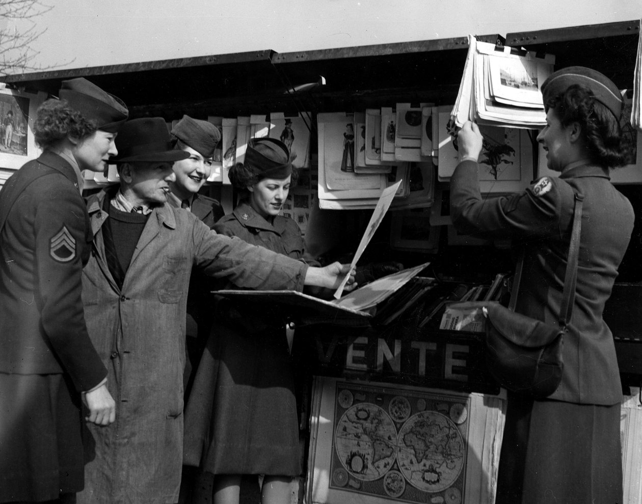Second World War (1939-1945): Paris (France) March 1945: Four Wacs (Women Army Corps) of the US Army discuss with a book player on the banks of the Seine. by Unbekannt