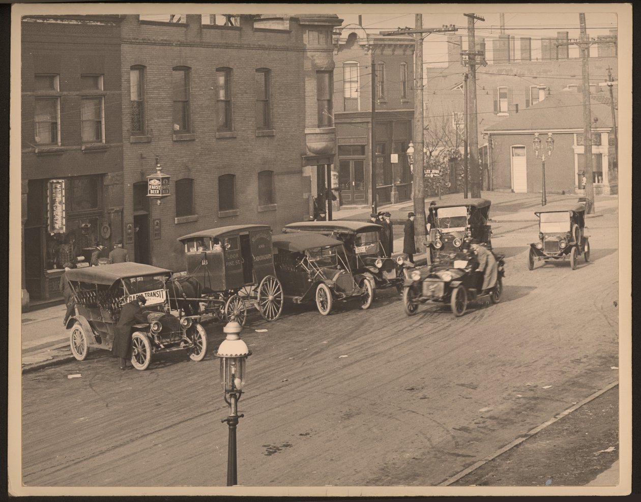 View of Unidentified Street with Several Automobiles and a Horse-Drawn Delivery Wagon from the St. Louis Bakery Company Parked Along the Curb by William G. Swekosky