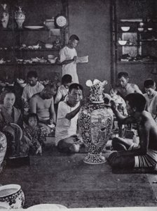 Porcelain decorators at work, in the noted Kinkosan Works at Awata, Kioto