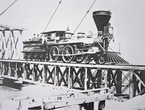 Locomotive of the US Military Railroads (Union Army) crossing trestle bridge over the Potomac River by American Photographer