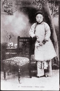 Portrait of a young Chinese woman in traditional costume. She has bound feet. Photography from the beginning of the 20th century. Private collection